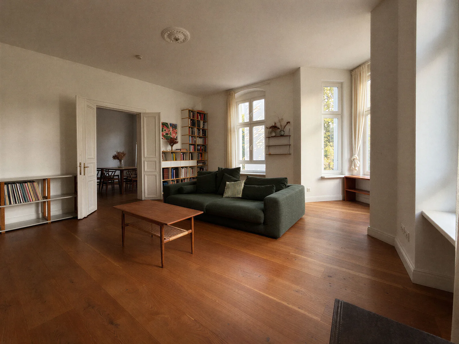 Living room with wood flooring, double doors and a bay window